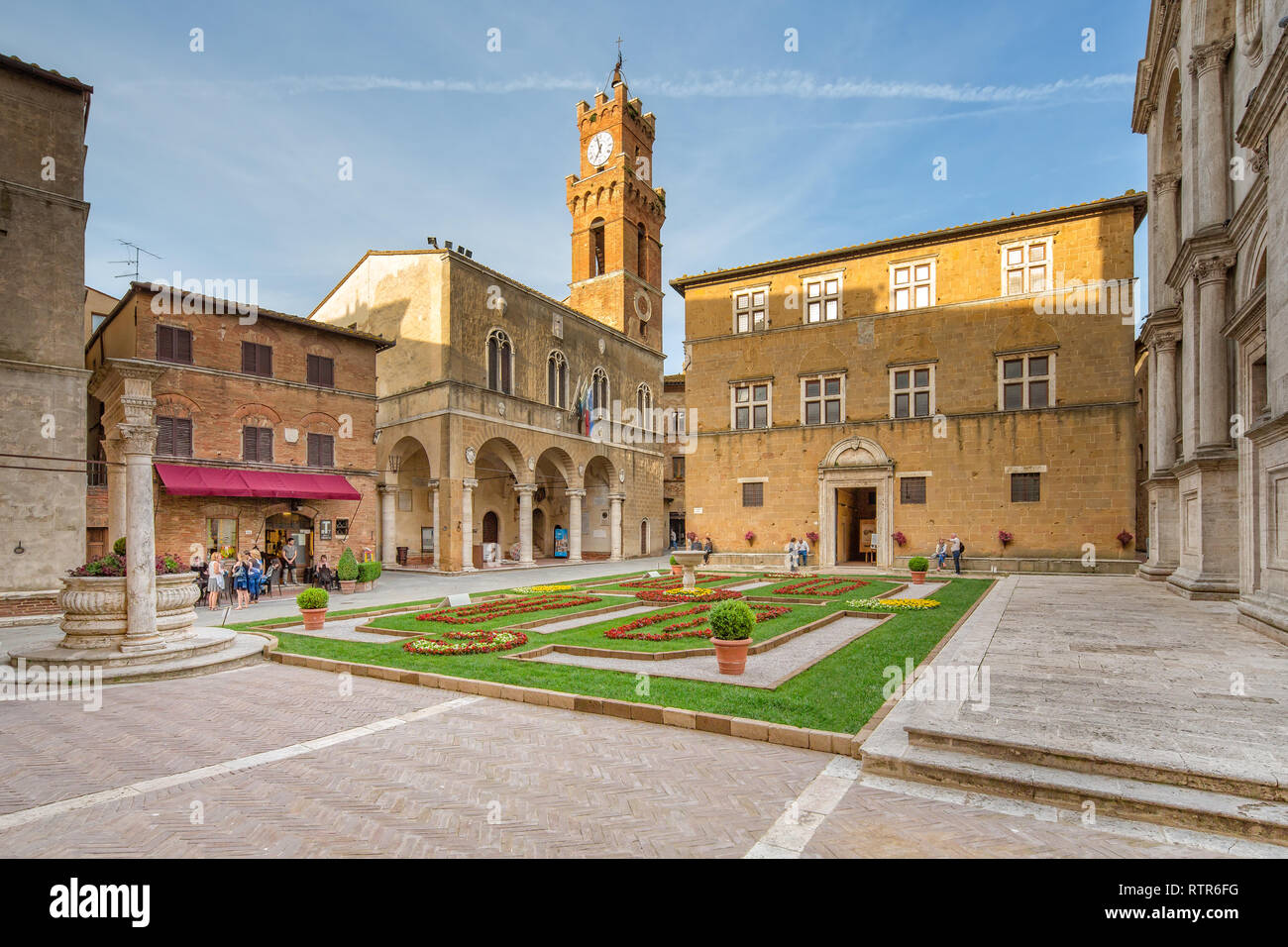 Pienza, Toscana/Italia - 10 de mayo de 2016: idílico con una fuente, plaza del ayuntamiento y de la Catedral de Pienza.turistas y gente local en la Piazza. Foto de stock