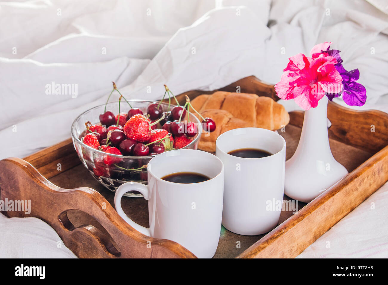 Desayuno en la cama para dos servido en una bandeja para el día de San  Valentín. Café con croissants y frutas Fotografía de stock - Alamy