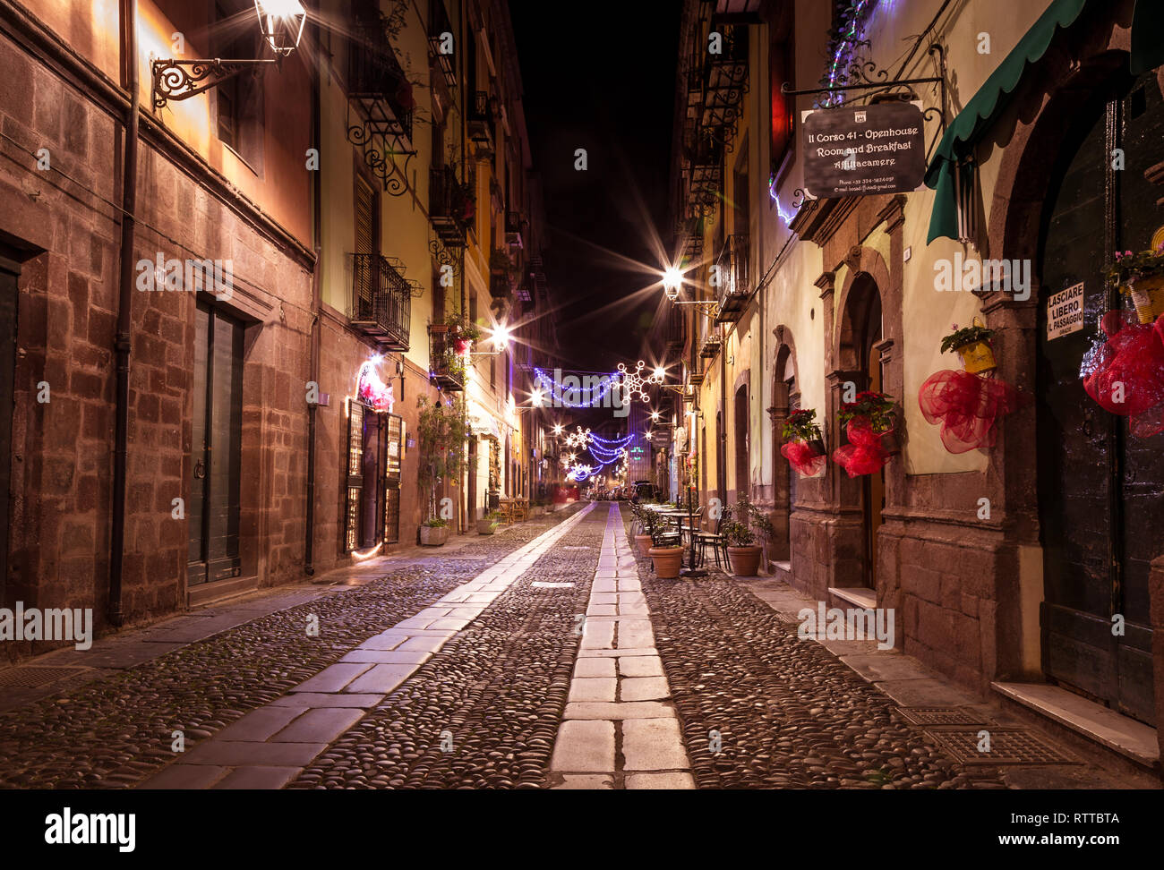 Bosa, isla Cerdeña Italia - 29 de diciembre de 2019: turista relajarse durante la noche en las antiguas calles de Bosa, Cerdeña, Italia Foto de stock