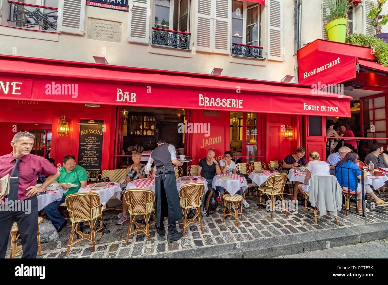 Un camarero que sirve a un cliente en La Mère Catherine, el restaurante más antiguo de Place du Tertre, Montmartre, París, Francia Foto de stock