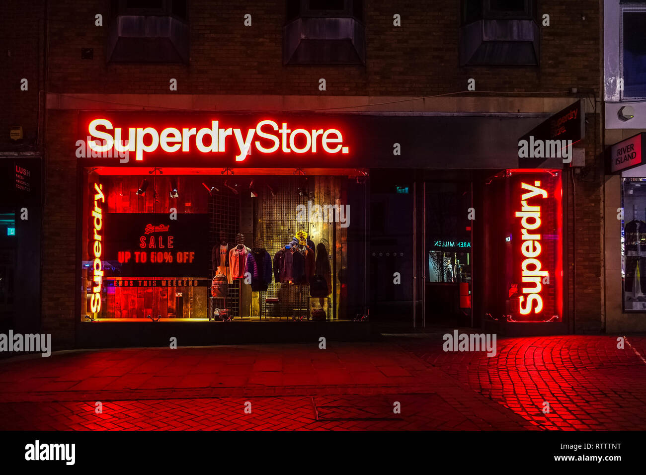 La Superdry store en la calle Peascod en Windsor se ilumina con luces de  neón rojo brillante brillando en la noche Fotografía de stock - Alamy