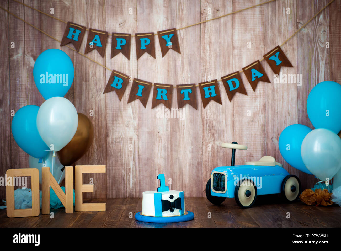 Photoshoot aplastar smashcake para un niño pequeño caballero. Decoradas con  un estilo retro de madera photozone coche y globos de helio. Feliz  cumpleaños, 1 año Fotografía de stock - Alamy