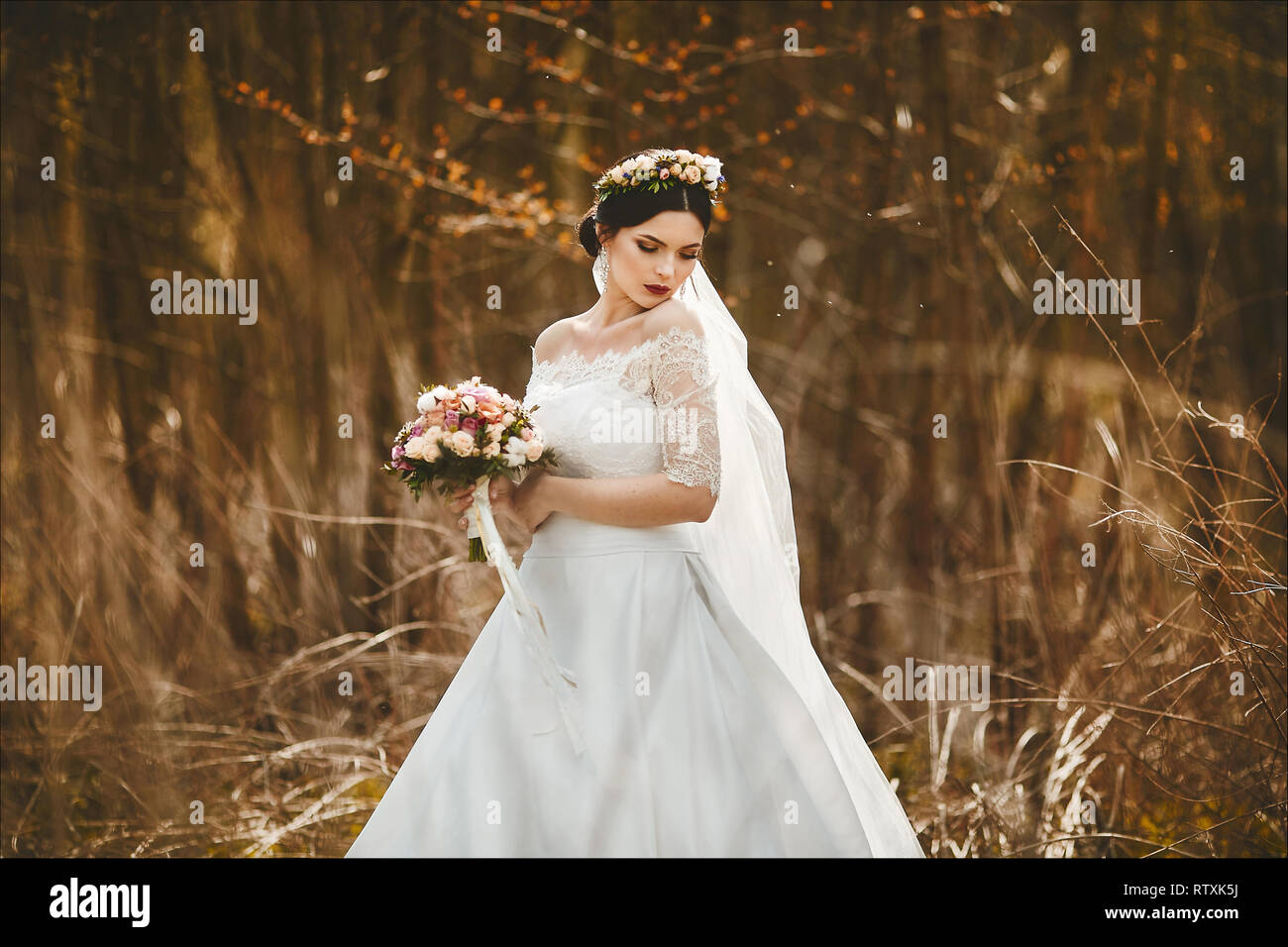 Elegante Y De Moda Joven Morenita Novia Con Maquillaje Y Brillante Con Una Corona De Flores En La Cabeza Elegante Vestido De Novia De Encaje Con Un Bouquet Fotografia De Stock
