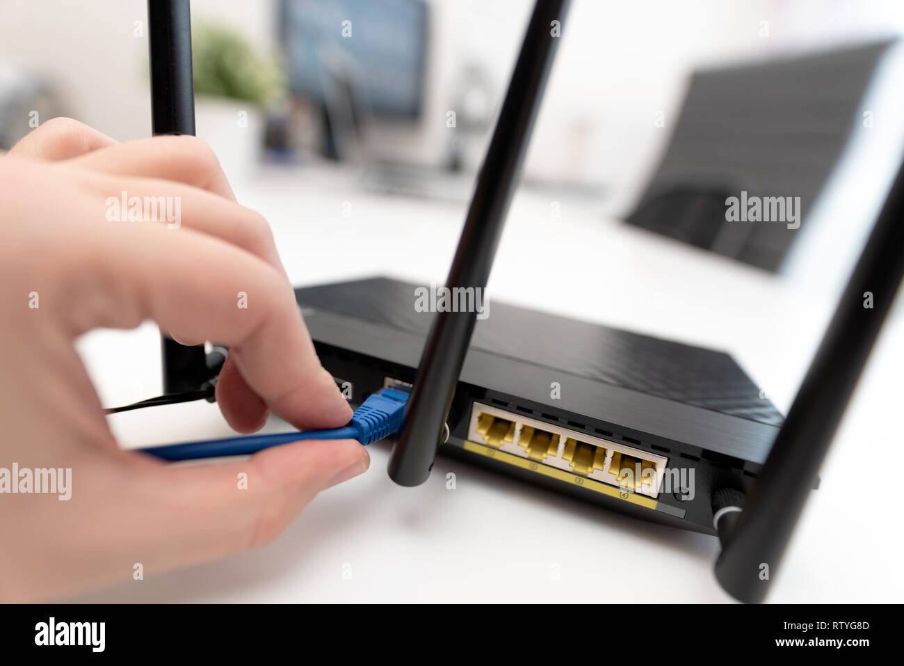El hombre se conecta el cable de internet al router la toma. Concepto de internet inalámbrico y rápido Foto de stock