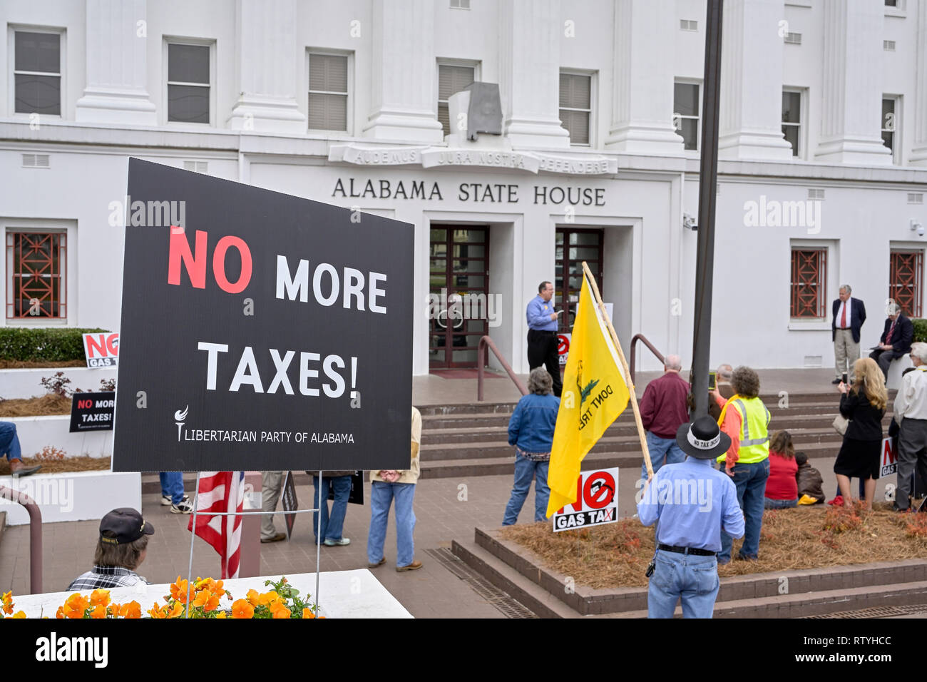 La gente escucha a un orador protestando por impuestos o un impuesto al gas con letreros en contra de más impuestos en el estado de Alabama Casa en Montgomery, Alabama, Estados Unidos. Foto de stock