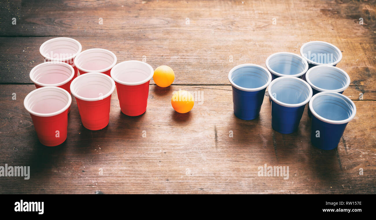 Beer pong, juego de fiesta universitaria. De color rojo y azul de plástico  copas y pelotas de ping pong sobre fondo de madera, vista desde arriba  Fotografía de stock - Alamy