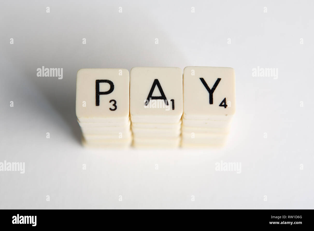 Azulejos deletrear la palabra 'pagar' simbolizando un aumento salarial Foto de stock