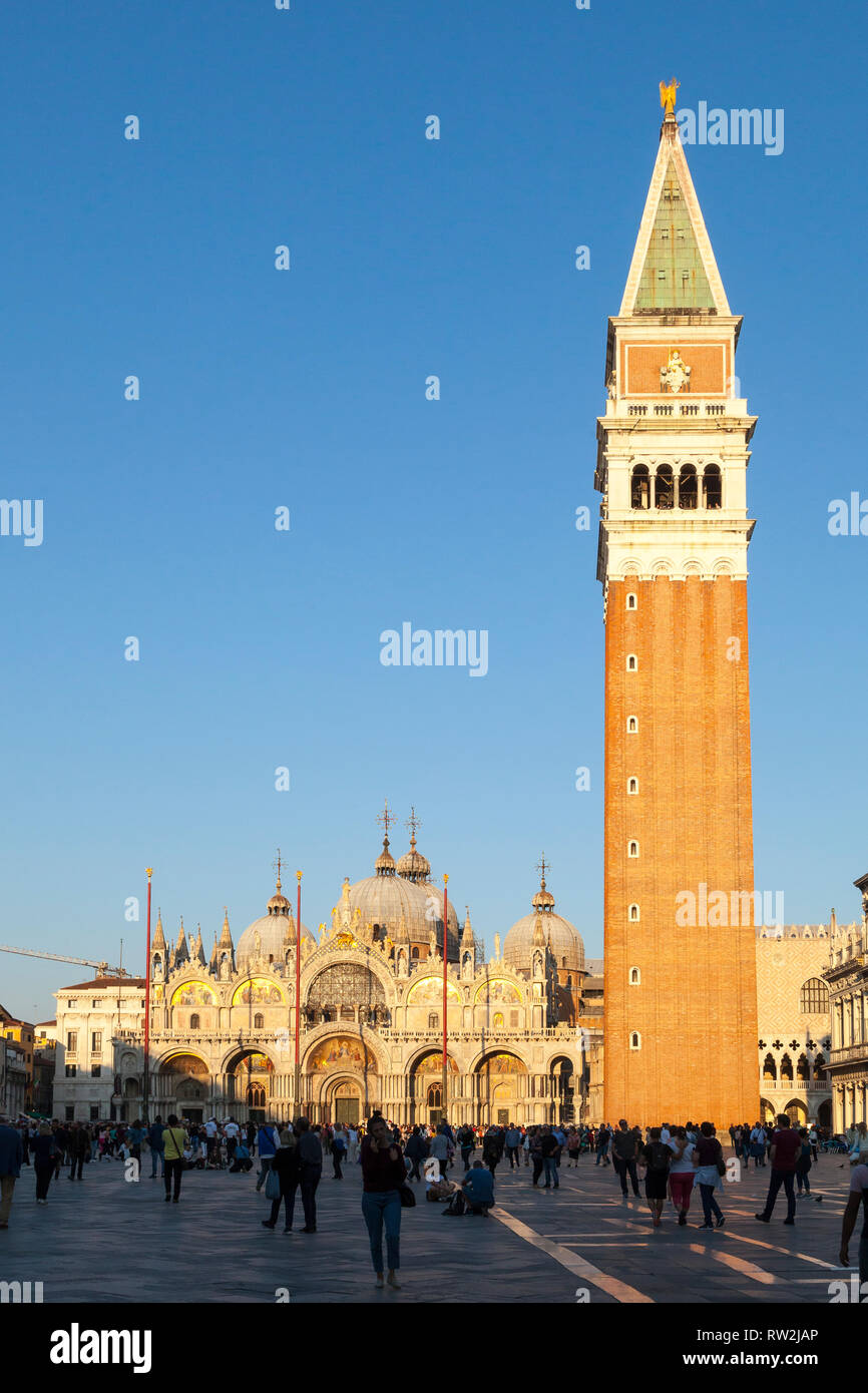 Sunet dorado a través de la Basílica de San Marcos y el Campanile, en Piazza San Marco, Venecia, Véneto, Italia con los turistas en esta popular atracción turística Foto de stock