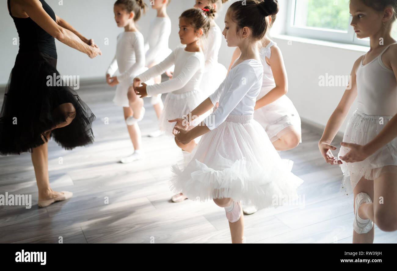Grupo de colocar niños felices ejerciendo ballet en studio juntos Foto de stock