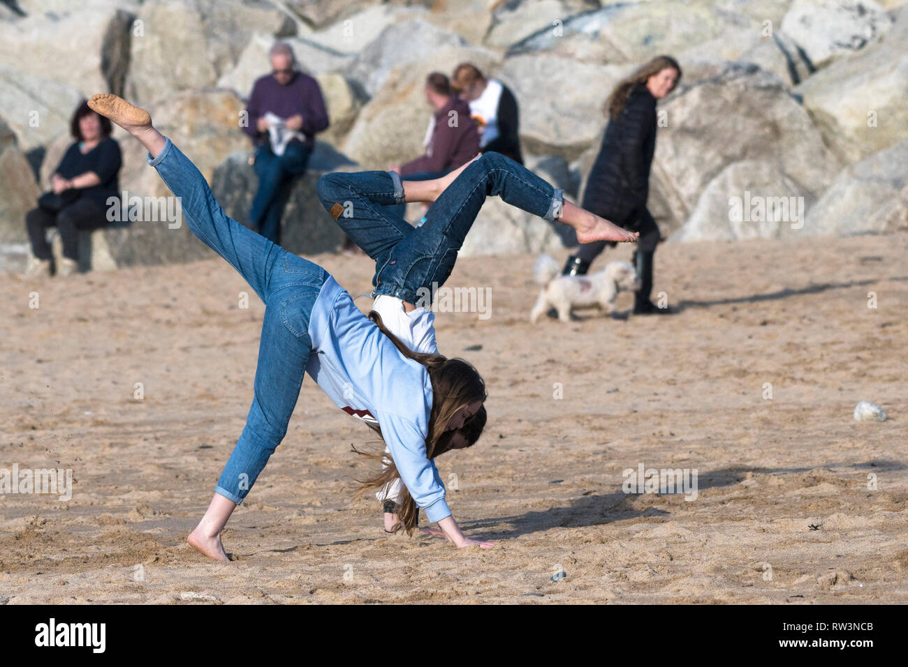 Jóvenes adolescentes haciendo handstands enérgica en Fistral Beach en Newquay, Cornwall. Foto de stock