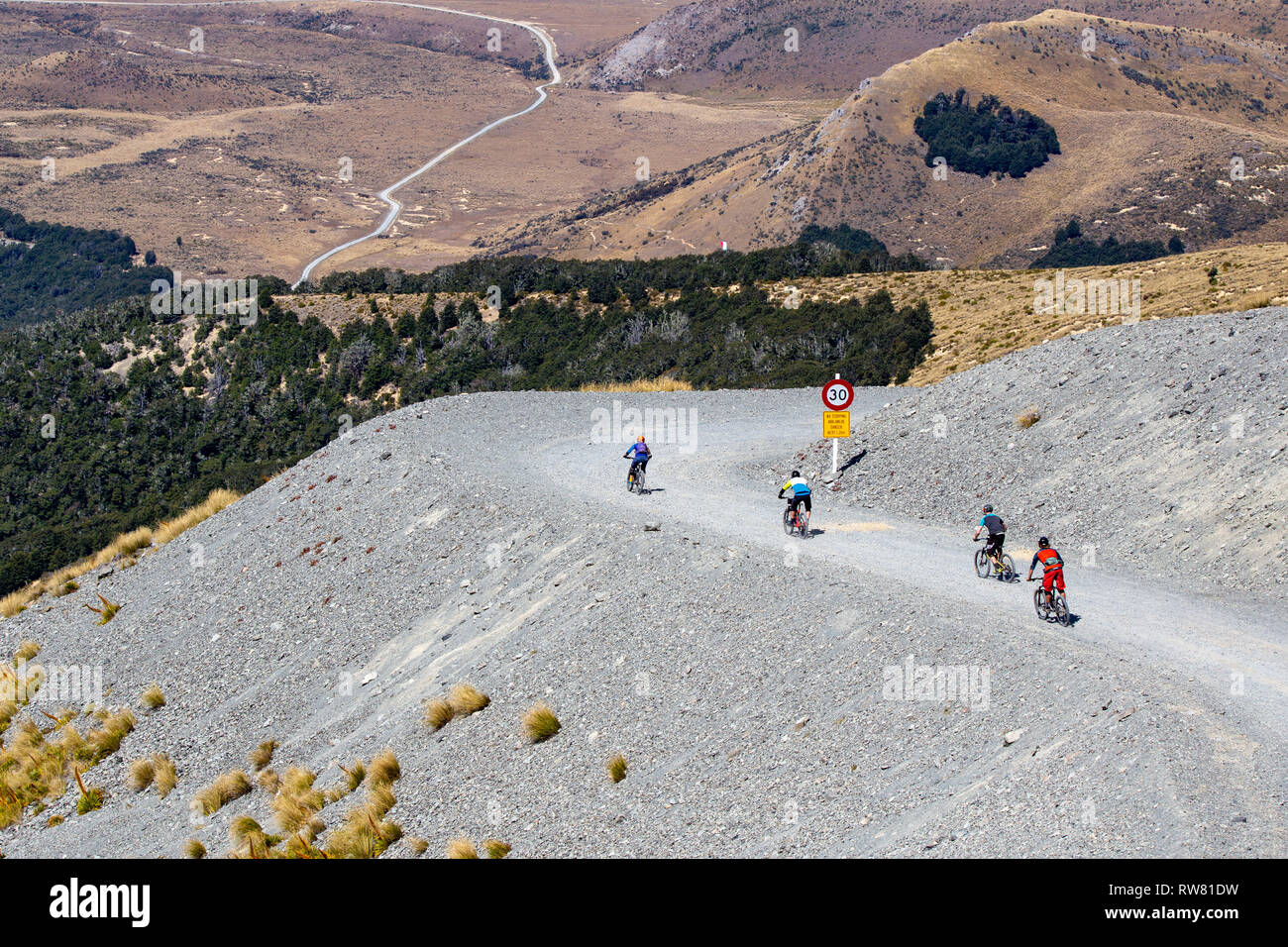 Mt Cheeseman, Canterbury, Nueva Zelandia, el 2 de marzo de 2019: Los ciclistas de montaña paseo campo de esquí el camino que lleva a la pista de mtb desde la cima de la montaña. Foto de stock