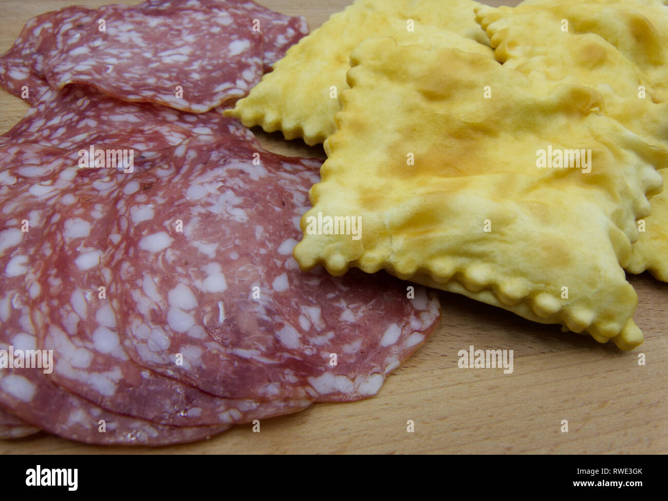 Crescentine gnocco fritto o con rodajas de salami, comida italiana tradicional de Módena o Bolonia, Italia Foto de stock