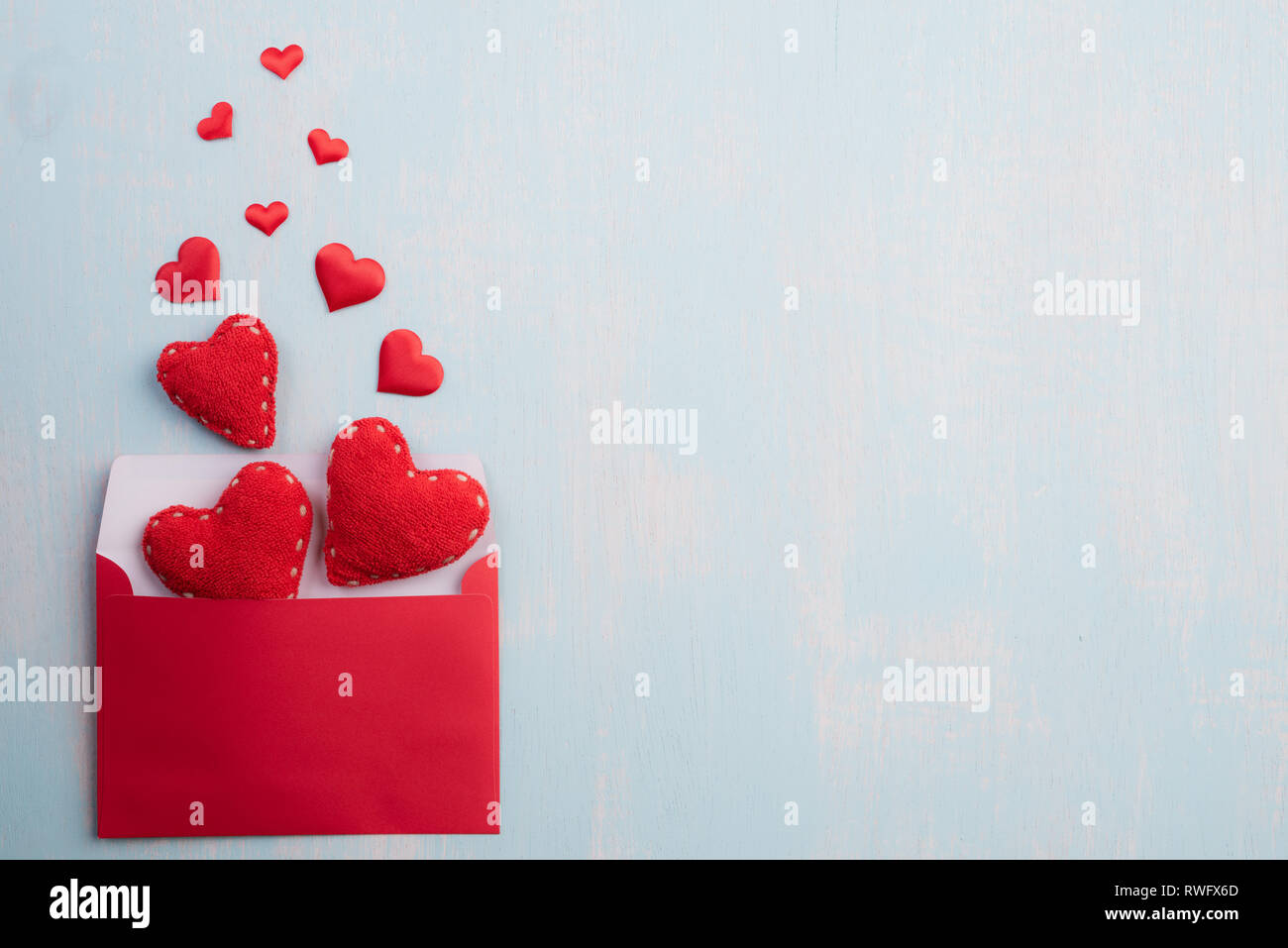 Día de San Valentín y el concepto de amor. Corazones rojos splash de rojo  rosa Portada carta sobre el cielo azul de fondo de madera Fotografía de  stock - Alamy