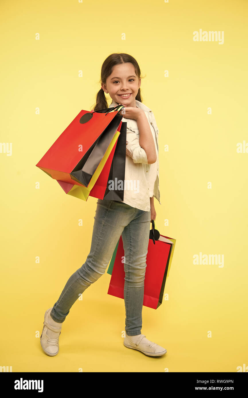 Cambiar mi estilo. Niño lindo fashionista shopping. Kid Felices compras en el mall. Chico Chica feliz rostro sonriente transporta paquetes de racimo de fondo amarillo. Chica shopaholic le gusta comprar ropa de Cambiar mi estilo. Niño lindo fashionista shopping. Kid Felices compras en el mall. Chico Chica feliz rostro sonriente transporta paquetes de racimo de fondo amarillo. Chica shopaholic le gusta comprar ropa de