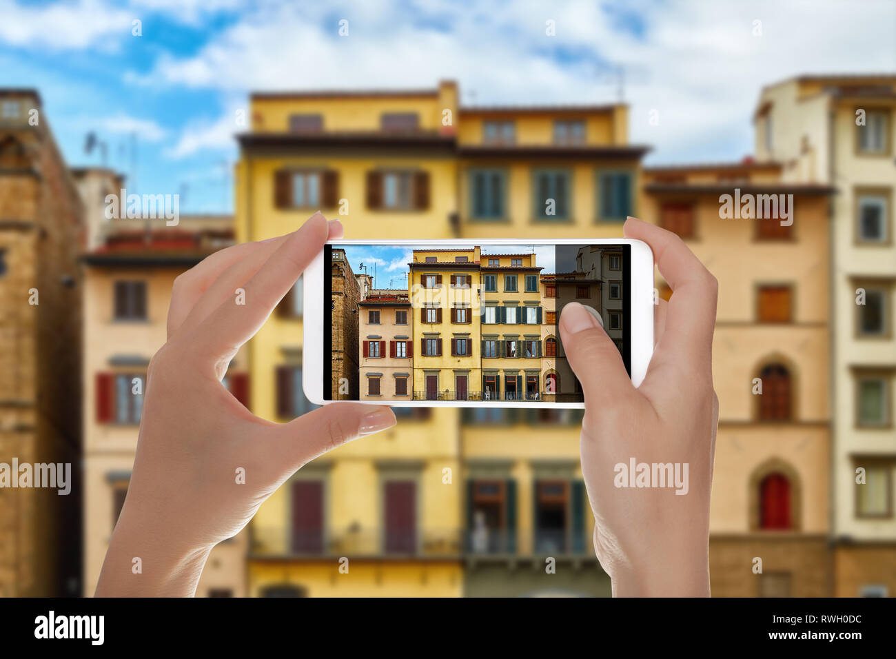 Un hombre está haciendo una foto de hermosas fachadas de viejos edificios italianos en la Piazza della Signoria en Florencia, Italia, en un teléfono móvil Foto de stock