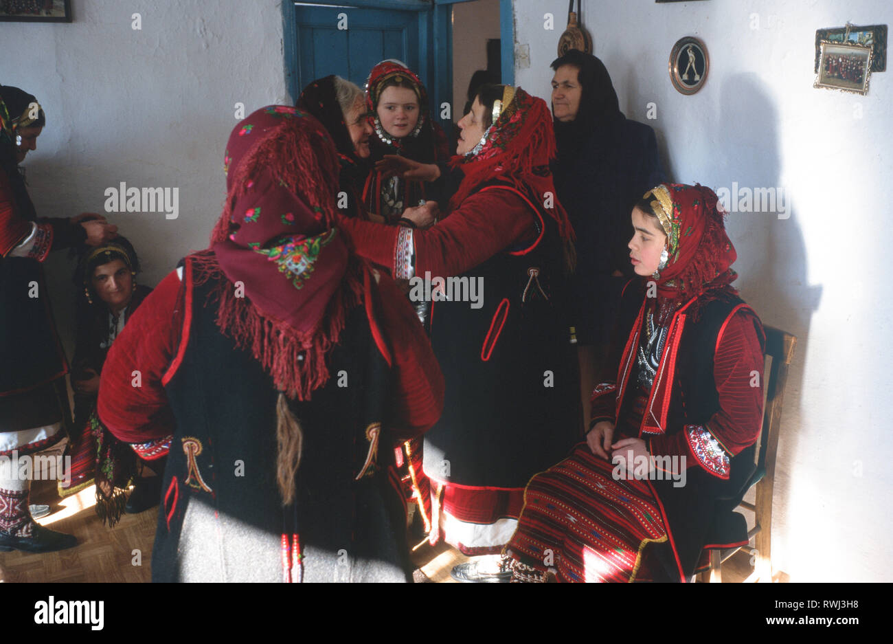 Las mujeres se reúnen en la casa de la novia-a-ser ante un simulacro de ceremonia de bodas tradicional durante el Año Nuevo Carnaval, Dhrama, al norte de Grecia. Foto de stock
