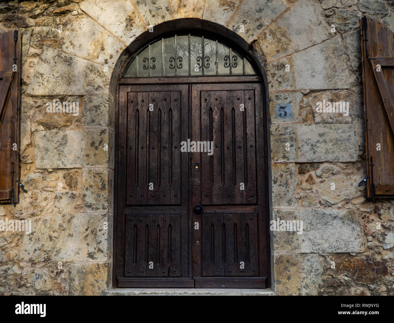 Puerta antigua en un edificio con un muro de piedra Foto de stock