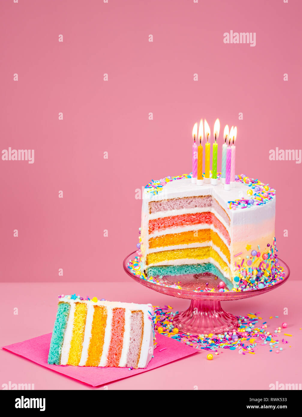 Arco Iris De Colores Pastel De Cumpleanos Con Velas Sobre Un Fondo De Color Rosa Fotografia De Stock Alamy