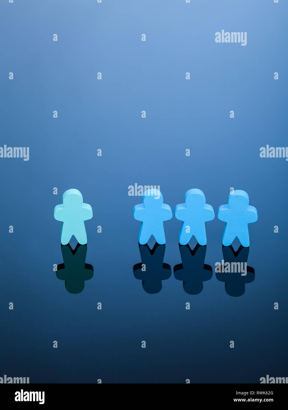 Azul de tres meeples excluir una luz verde. Imagen simple que representa el concepto de discriminación, las minorías en la sociedad o derechos desequilibrada. Foto de stock
