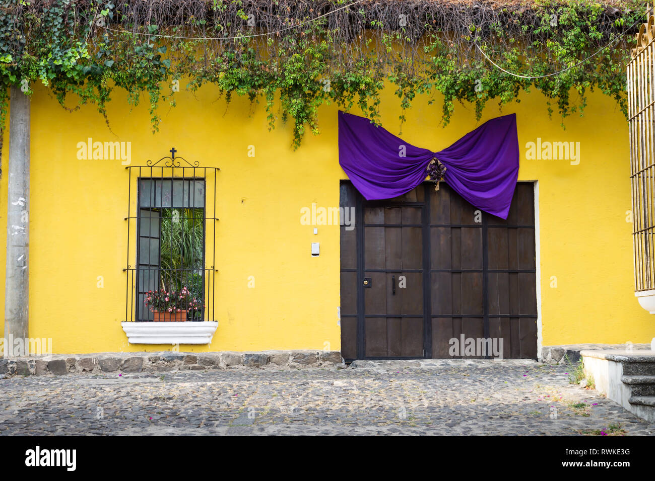 La casa amarilla de madera con puerto y purple ribbon como decoración para  Pascua - Semana Santa en Antigua, Guatemala Fotografía de stock - Alamy