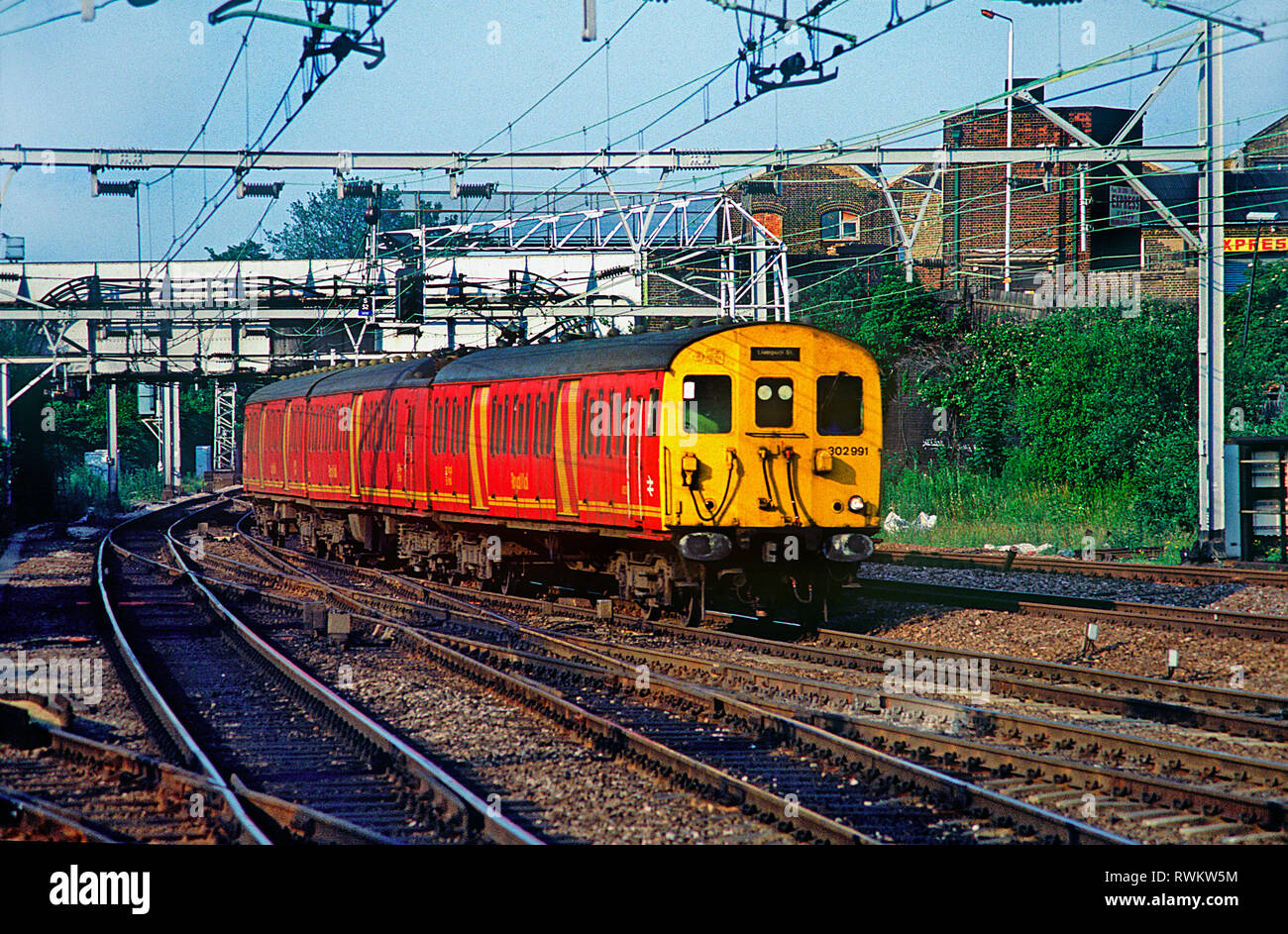 Paquetes clase 302 número de unidad 302991 pasando Stratford en el este de Londres. 4 de julio de 1991. Foto de stock