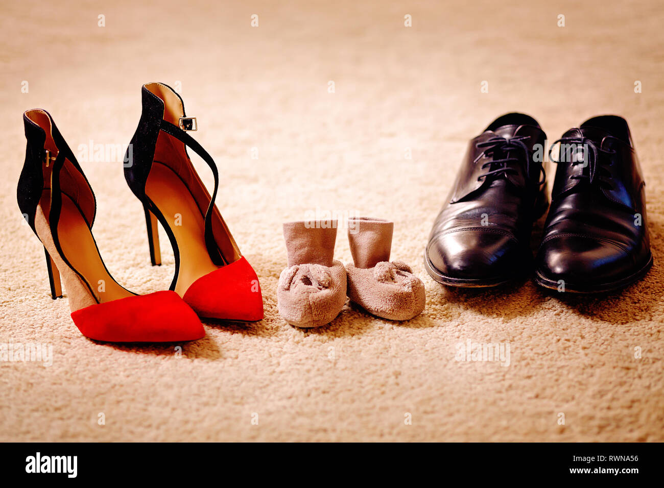 Patucos entre padres sus zapatos. Los padres esperando para el bebé  Fotografía de stock - Alamy