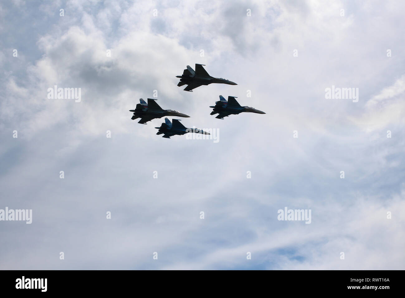 Cuatro aviones cazas de combate SU-34 combatientes militares volando en el cielo una gran potente Foto de stock