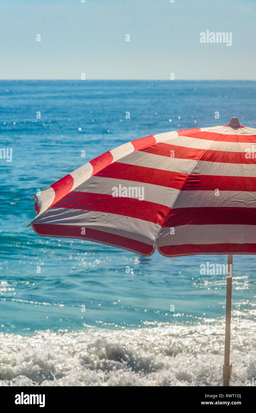 Brillantes sombrilla en la playa con el océano en teh Antecedentes Foto de stock