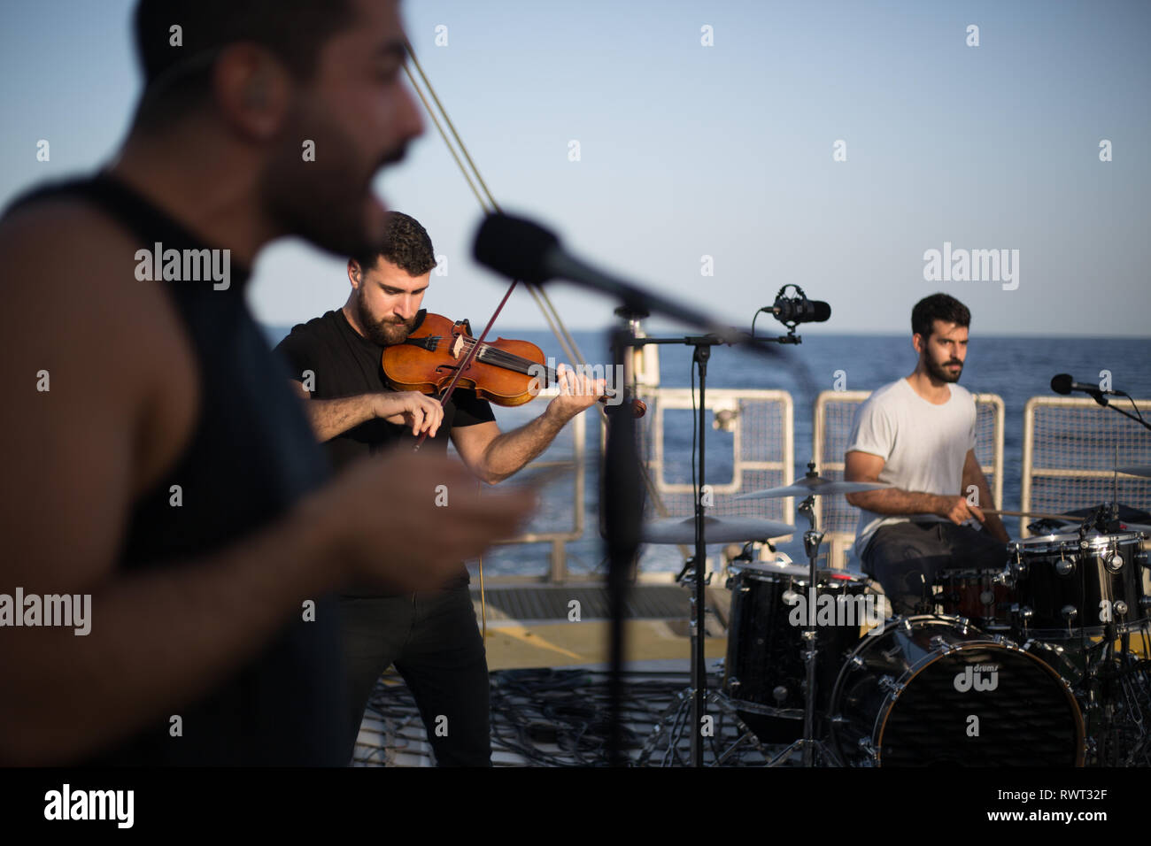 Banda libanesa Mashrou' Leila configurar y preparar para grabar una canción a bordo del barco de Greenpeace Rainbow Warrior en el sol nos une tour, el Mar Mediterráneo, el 23 de octubre de 2016. N37°55.826' E8°46.256' Foto de stock
