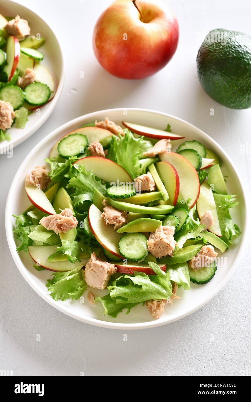 Ensalada de atún con rodajas de pepino, el aguacate, la manzana roja en un  tazón sobre fondo de piedra blanca. Dieta saludable comida Fotografía de  stock - Alamy