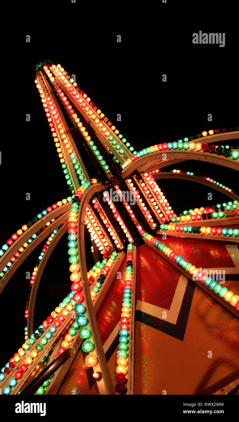 Fotografía abstracta de luces de Carnaval contra el cielo nocturno. Foto de stock