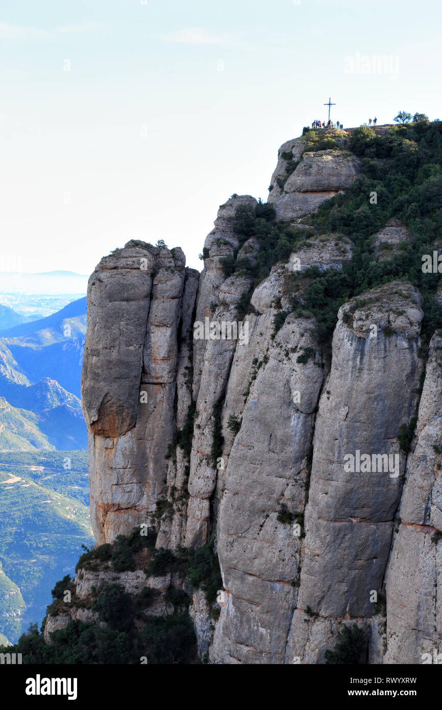 Montserrat las montañas de piedra caliza con la cruz de San Miguel en la parte superior, Cataluña, España Foto de stock