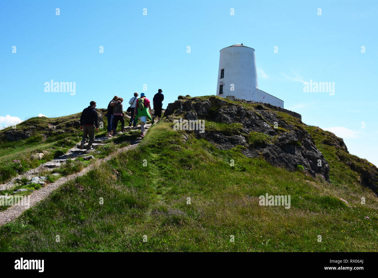 Caminando hasta Twr Mawr Llanddwyn faro en la Isla de la costa de Anglesey Foto de stock