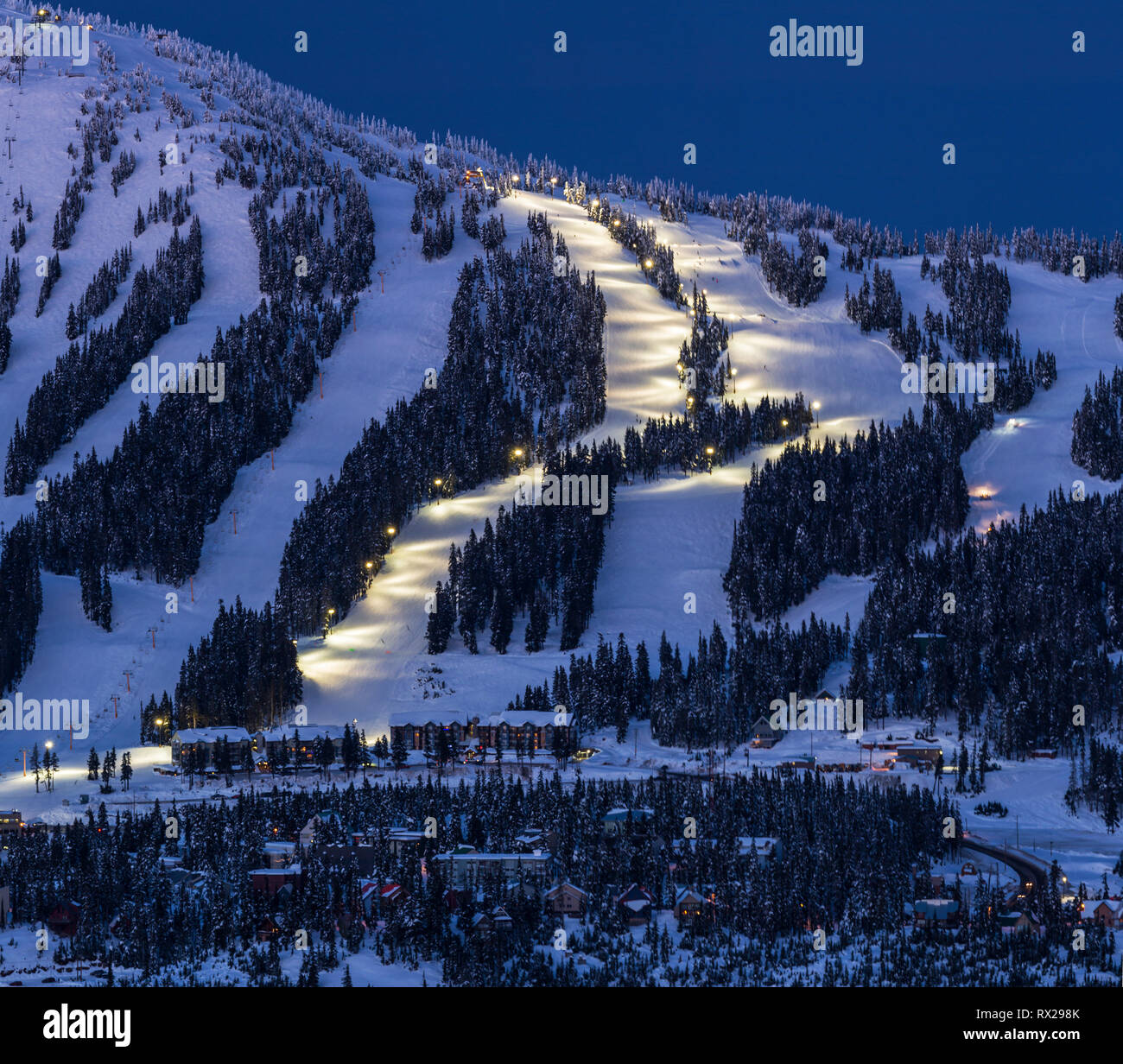 El esquí nocturno se ilumina en la estación de esquí de Mount Washington mientras el atardecer se asienta en la popular estación de esquí de la isla de Vancouver, el valle Comox, la isla de Vancouver, la Columbia Británica, Canadá. Foto de stock