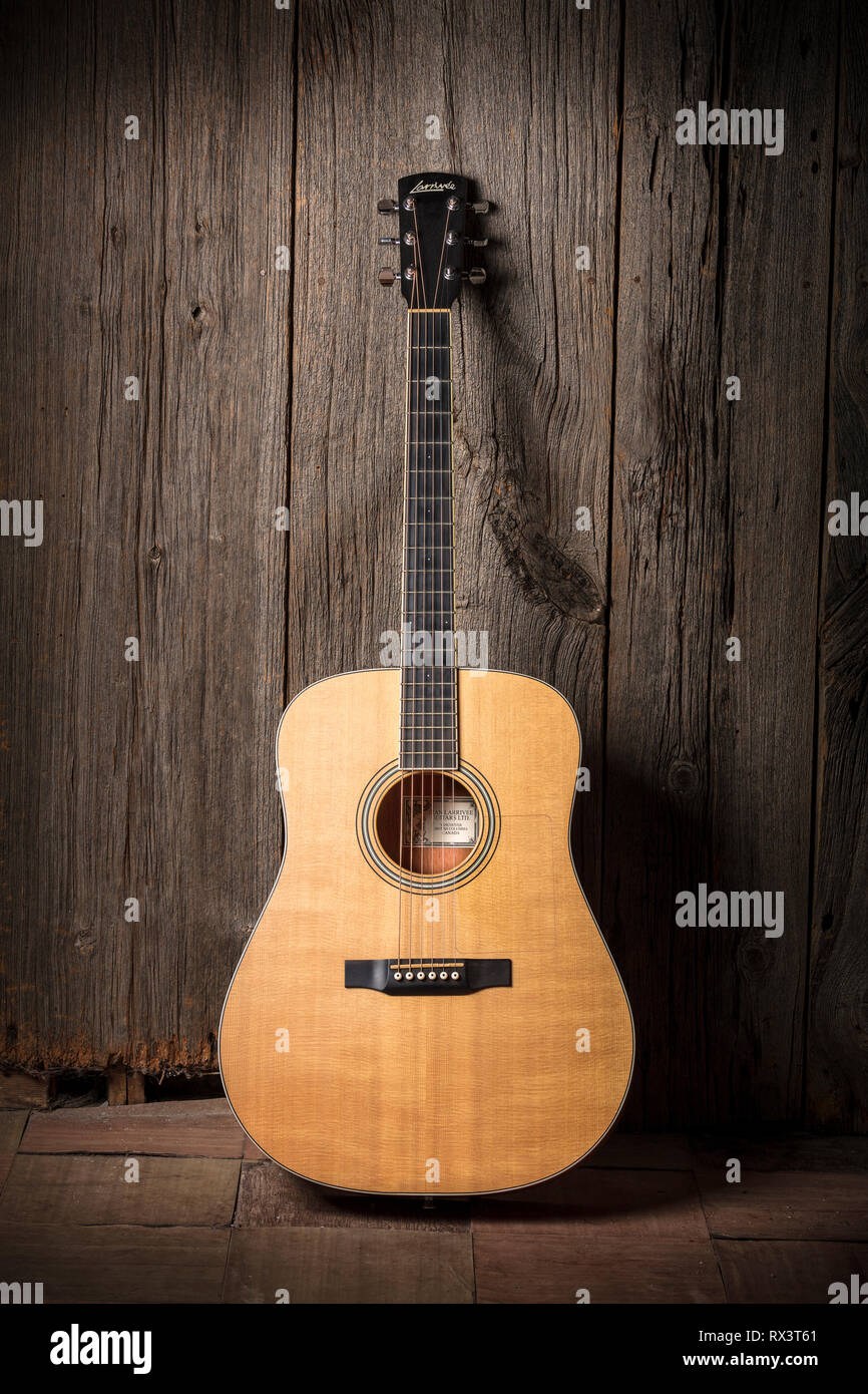 Guitarra acústica Larrivée apoyado contra una pared junta granero de madera Foto de stock