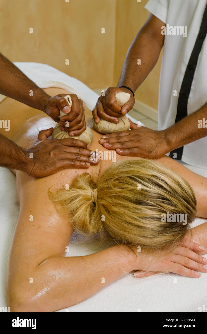 Mujer recibiendo el masaje con compresas de hierbas Foto de stock