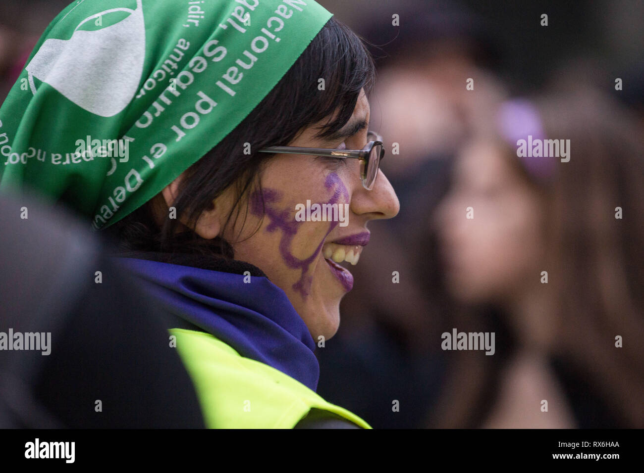 Una mujer con logo feminista pone un pañuelo verde visto sonriendo durante  la protesta del día Internacional de la Mujer en Madrid. Miles de mujeres  protestan contra la desigualdad entre géneros, precariedad,