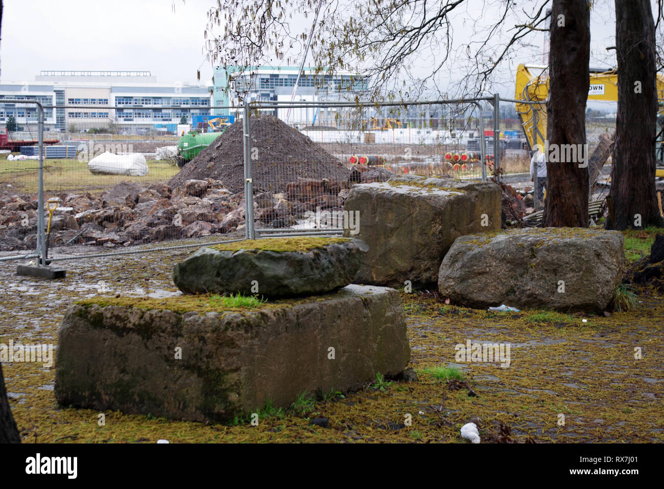 Viejas piedras angulares del astillero sentado al lado de Glasgow road, West College Clydebank, Escocia en el fondo. Foto de stock