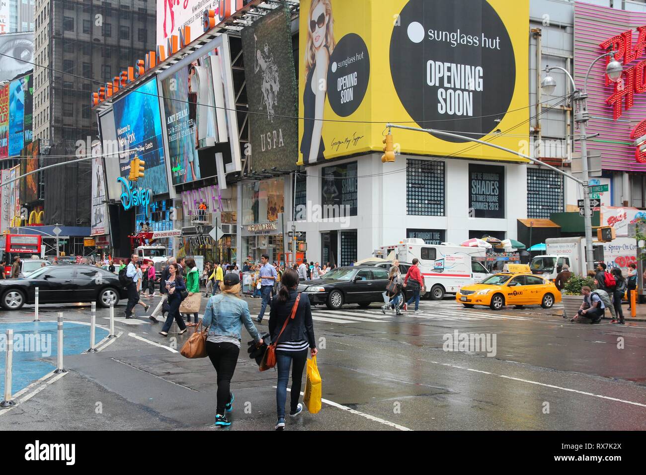Nueva York, Estados Unidos - Junio 10, 2013: la gente visita lluvioso Times Square, NY. Times Square es uno de los lugares más reconocidos en el mundo. Más de 300.000 púb Foto de stock