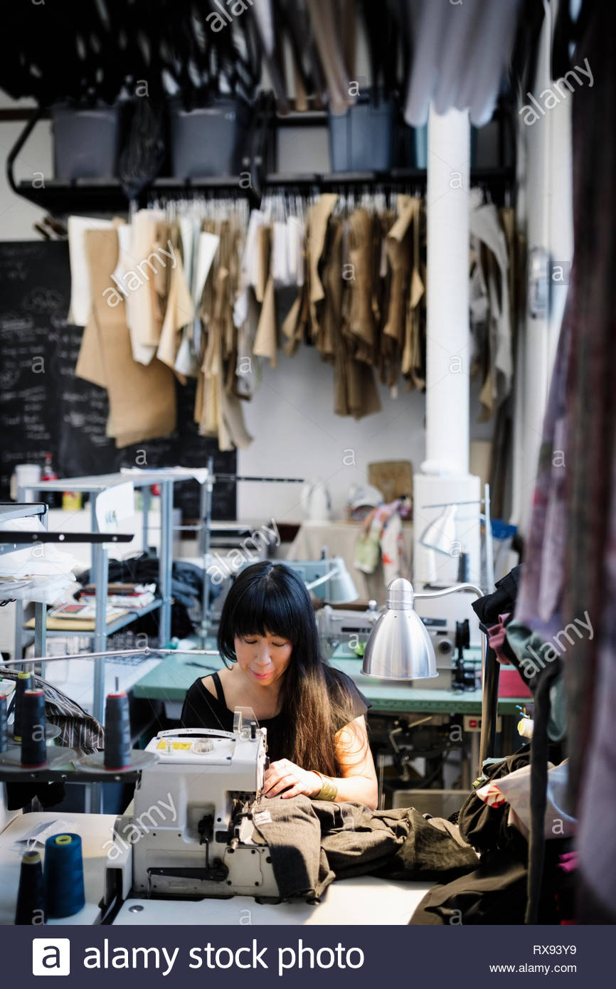 Costurera hembra con máquina de coser en studio Foto de stock