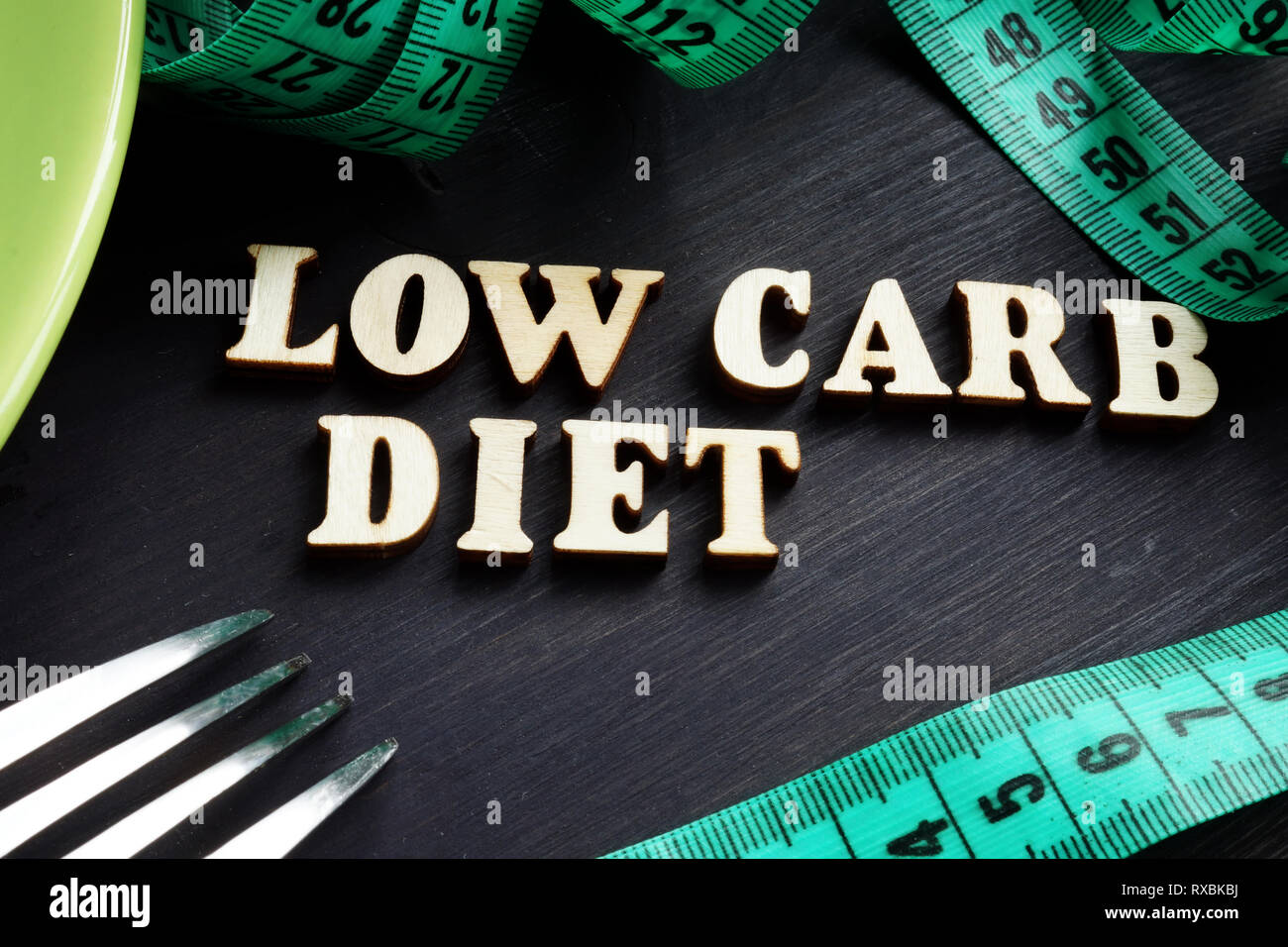 Concepto de dieta baja en carbohidratos. Placa verde con un tenedor. Foto de stock