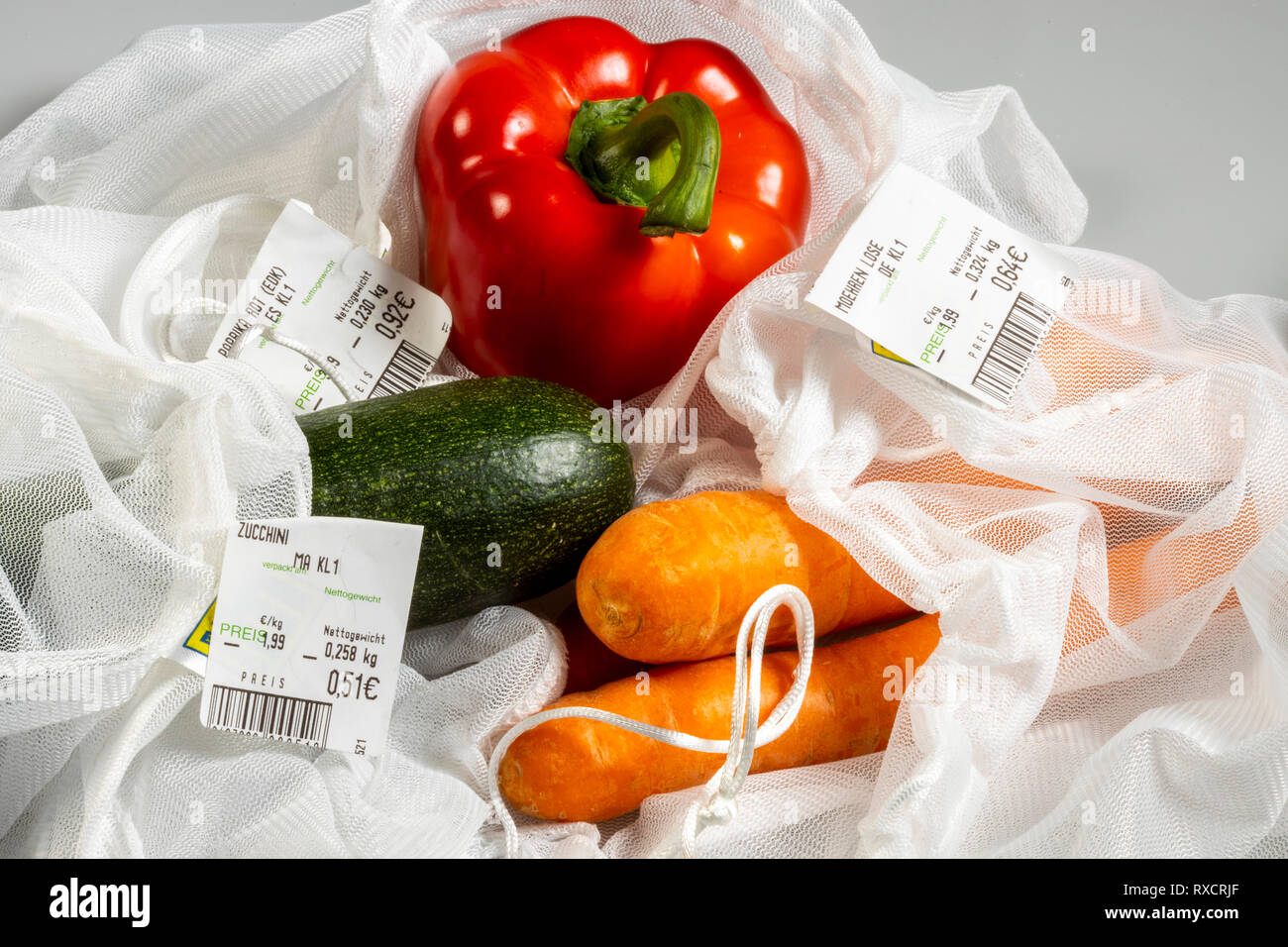 Los envases para alimentos, los pimientos, las zanahorias, los calabacines en una red de plástico reutilizables, para evitar los residuos plásticos, precio, Foto de stock