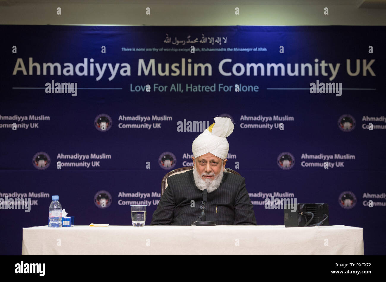 Su Santidad Hazrat Mirza Masroor Ahmad, habla en una conferencia de prensa durante el Encuentro Nacional por la paz, en la mezquita Baitul Futuh, moderno, de Londres. Foto de stock