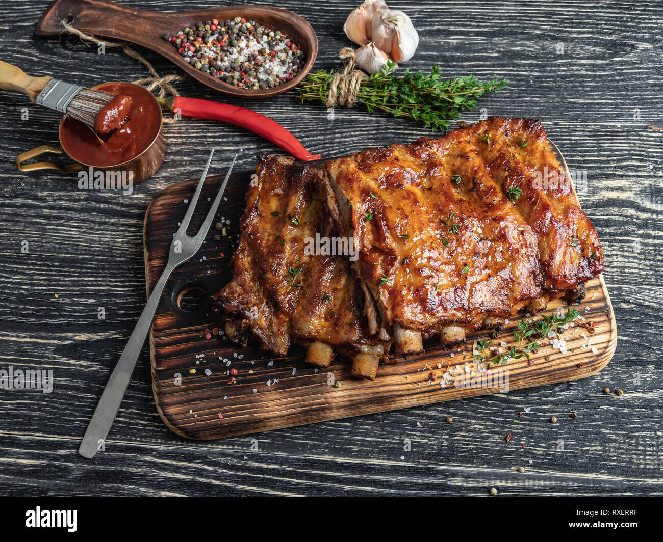 Costillas de cerdo a la parrilla con salsa sobre una tabla para cortar ,  especias, marinado Fotografía de stock - Alamy