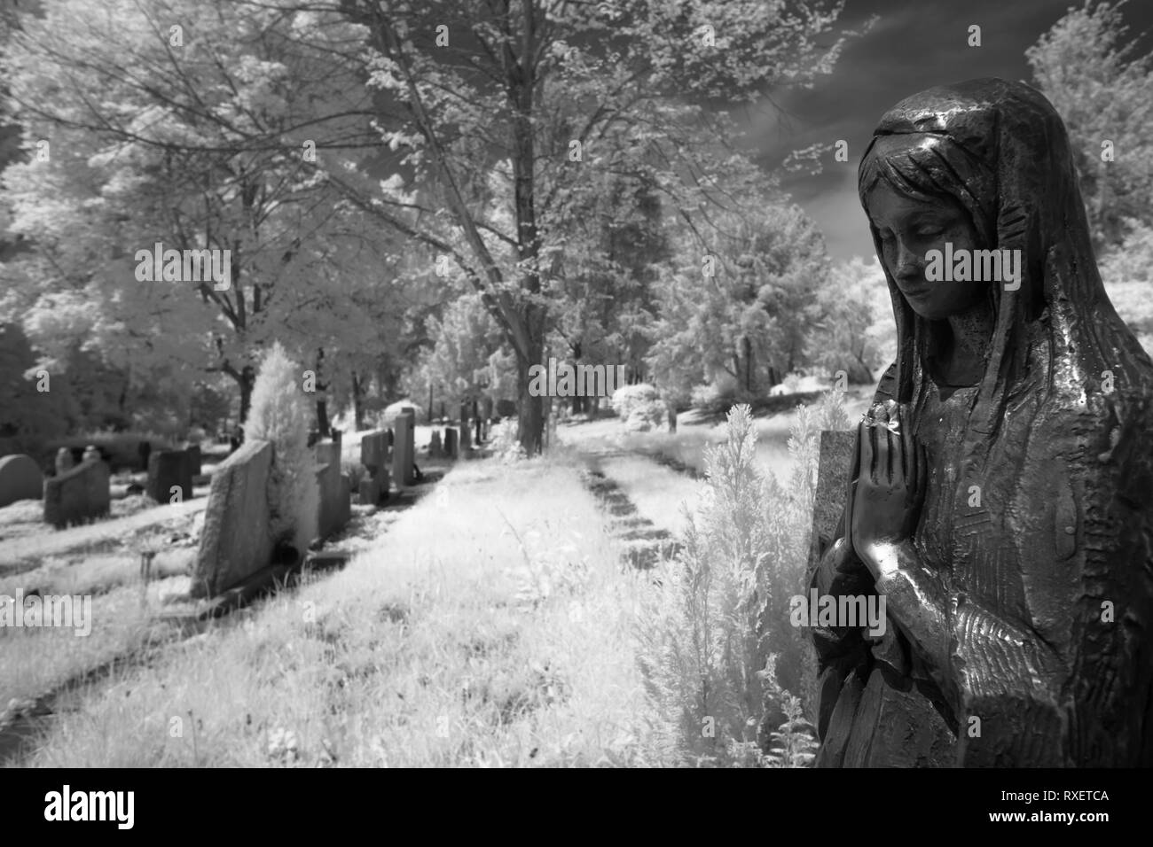 Estatua De Bronce Está Orando En Un Cementerio De Infrarrojos En Blanco Y Negro Fotografía De