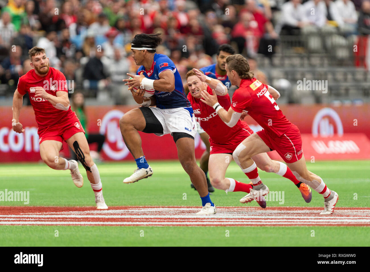 Vancouver, Canadá. 9 de marzo de 2019. Solia Tofatu (azul) perseguido por Lucas McCloskey (derecha) y Connor Braid de Canadá. 2019 HSBC Sevens-Day Rugby de Canadá. El BC Place Stadium. © Gerry Rousseau/Alamy Live News Foto de stock