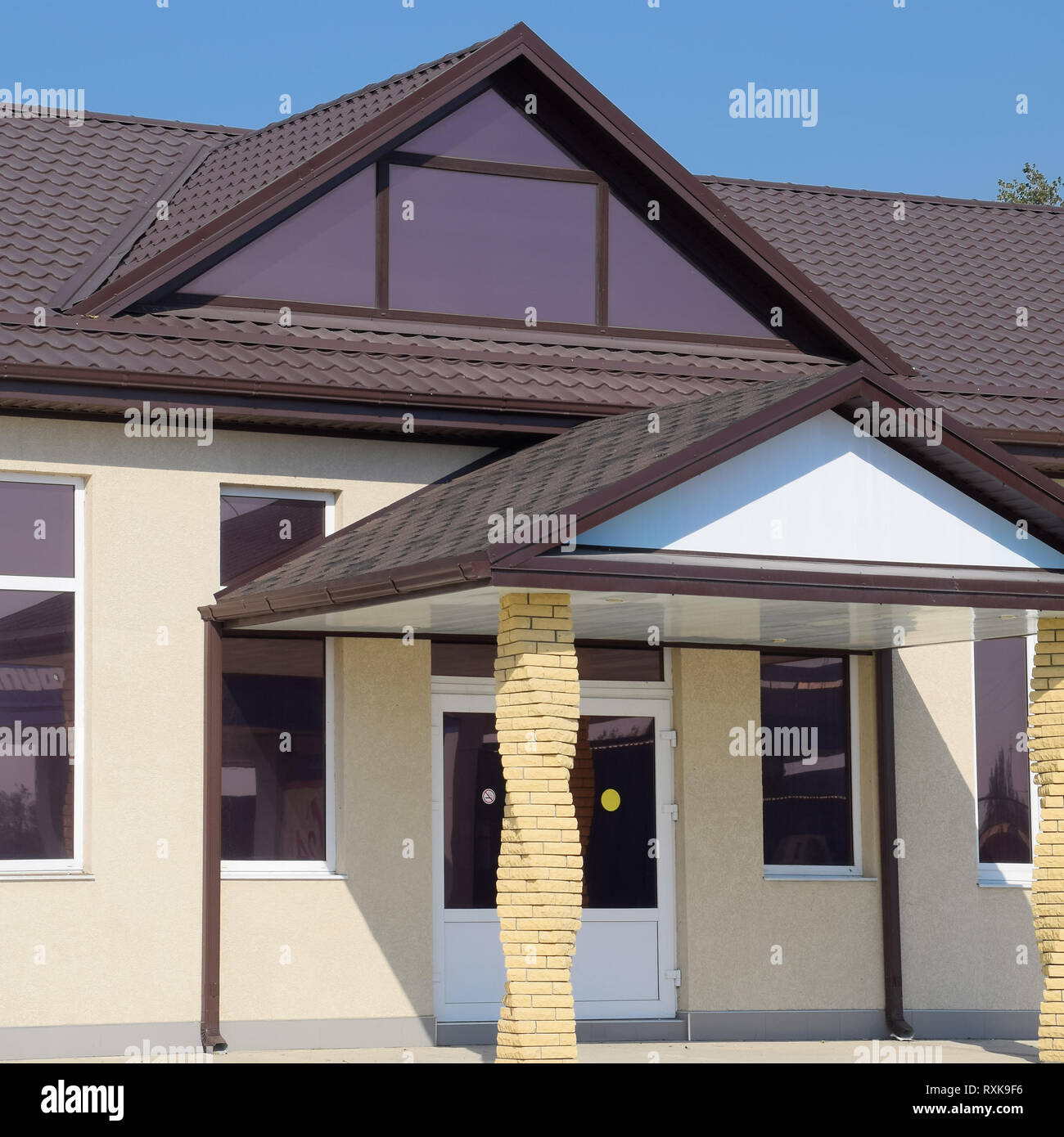 Edificio con techo de color marrón. La entrada principal de la casa. Los  materiales modernos de acabado y techado Fotografía de stock - Alamy