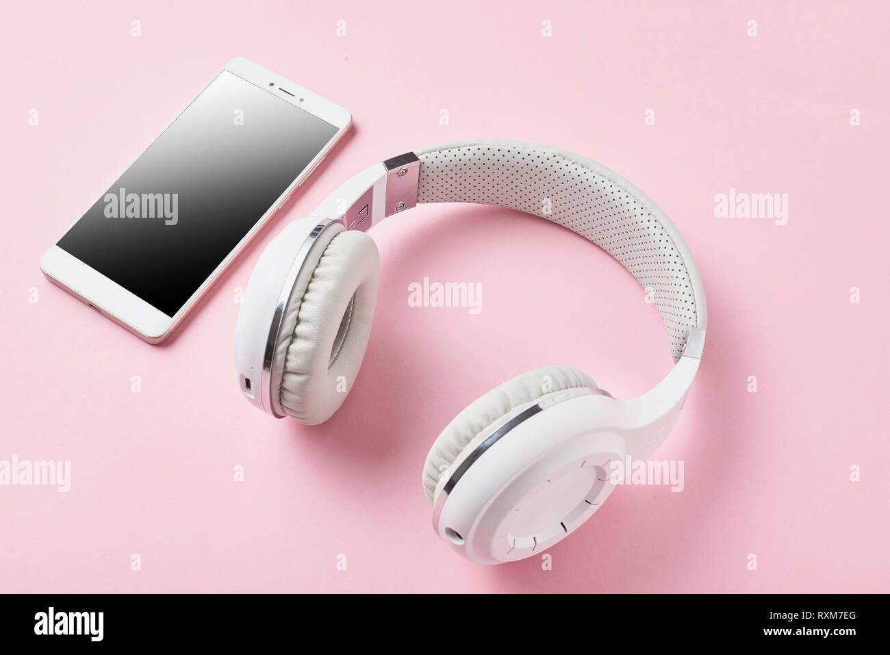 Auriculares inalámbricos y blanco sobre fondo de color rosa pastel  smartphone Fotografía de stock - Alamy