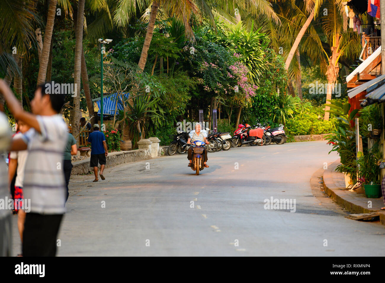 La vida diaria en las calles de Luang Prabang con la población local y los turistas que visitan la ciudad. Foto de stock