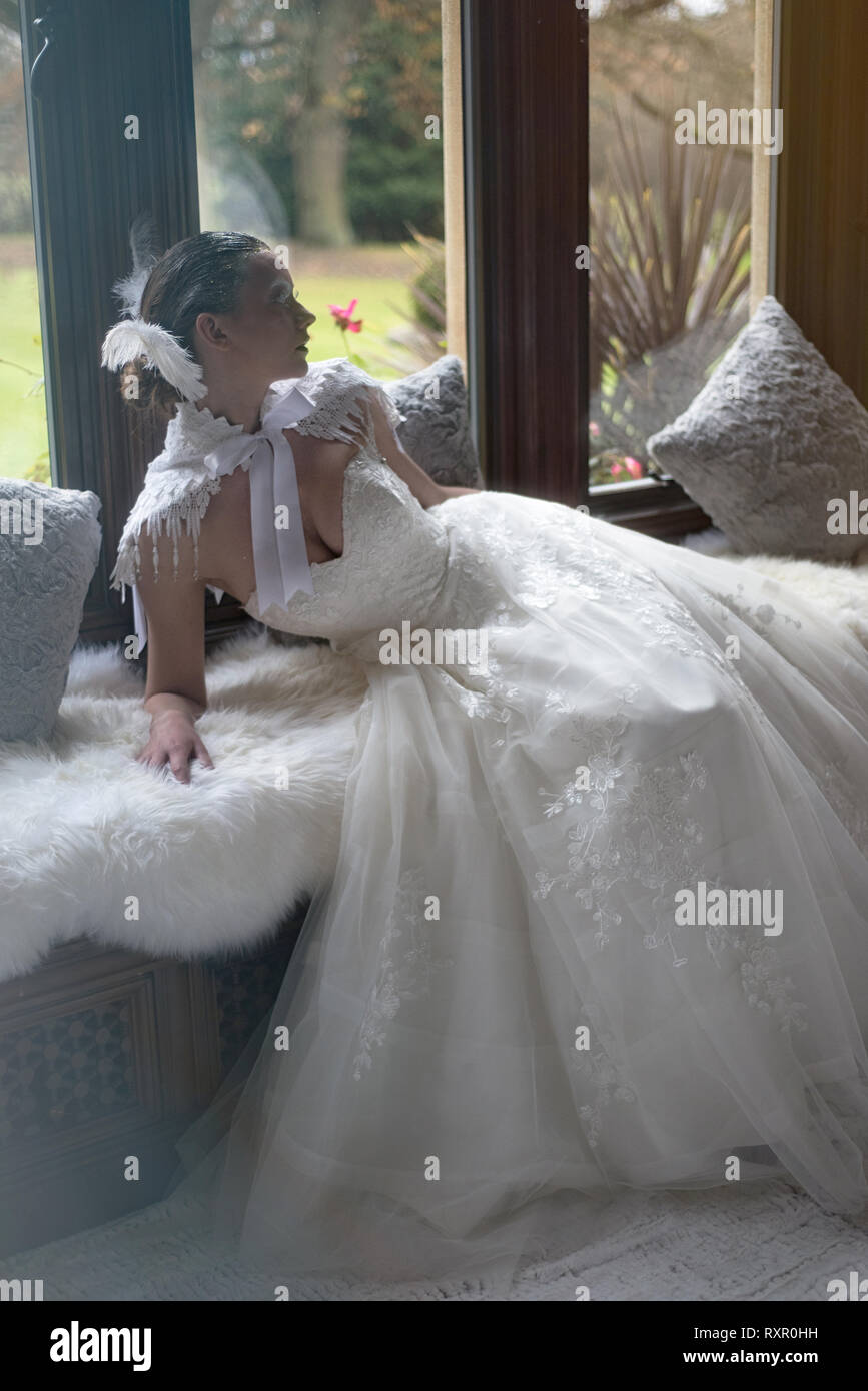 Una hermosa chica del Cáucaso en un largo vestido blanco plantea  dramáticamente en un estilo gótico para una editorial photo shoot. El tema  es cuento de invierno Fotografía de stock - Alamy